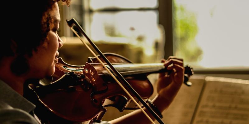 Violoniste jouant avec son archet devant une partition