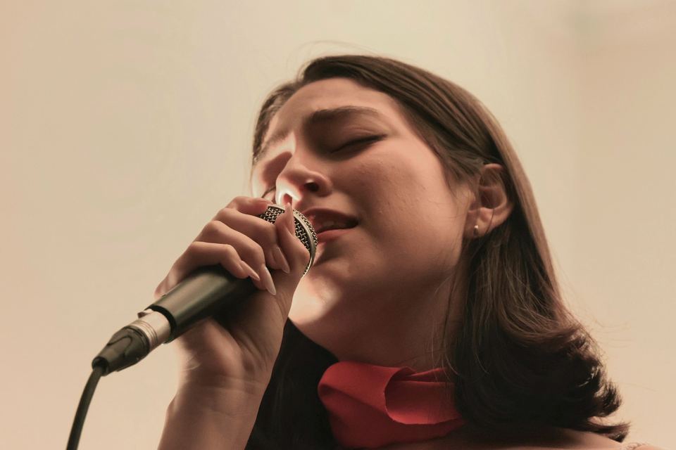 Chanteuse, les yeux fermés, chantant au microphone