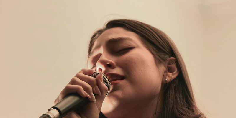 Chanteuse, les yeux fermés, chantant au microphone